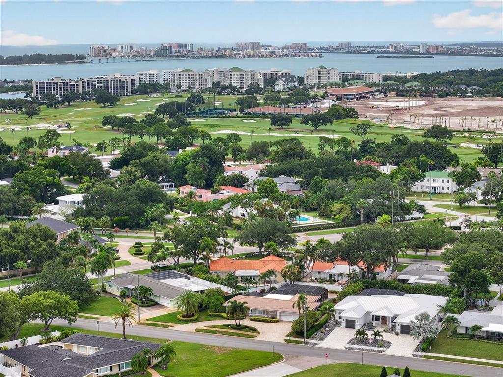 An aerial view of a suburban neighborhood with houses, trees, and a golf course nearby — 802 OSCEOLA ROAD, BELLEAIR, FL