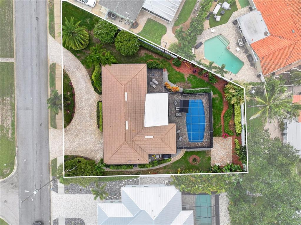 An aerial view shows a house with a tiled roof, a pool enclosure, and landscaping — 802 OSCEOLA ROAD, BELLEAIR, FL