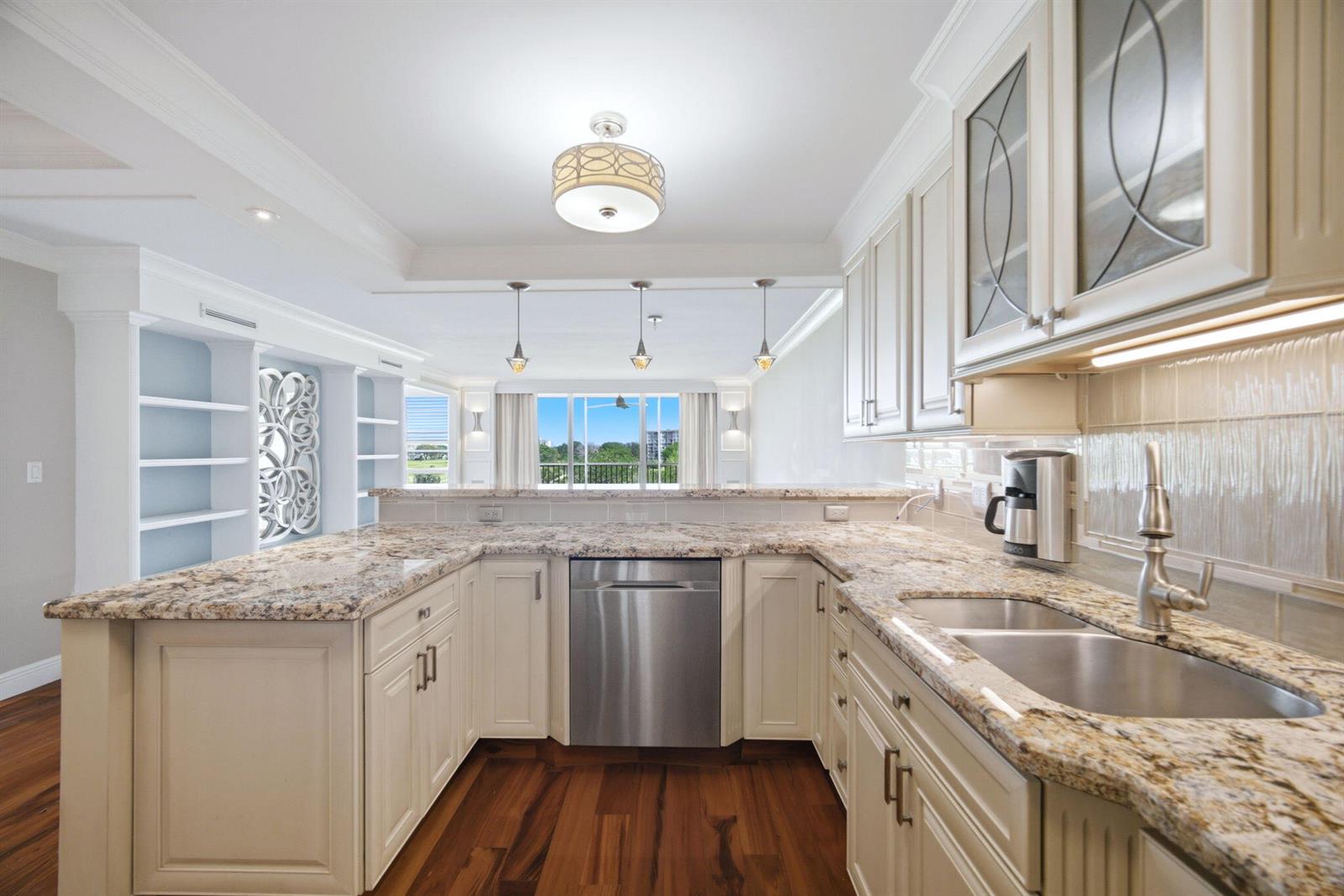 A kitchen with cream cabinets, granite countertops, stainless steel appliances, and wood flooring — 2901 S Palm Aire Drive, Pompano Beach FL 33069, POMPANO BEACH, FL