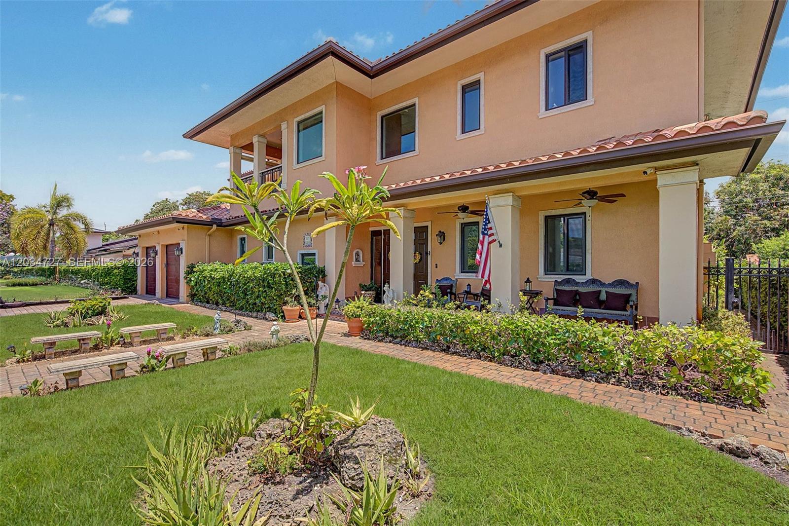 A two-story peach-colored house features a covered front porch, a brick walkway, and a landscaped lawn — 4251 SW 11th St, Miami FL 33134, MIAMI, FL
