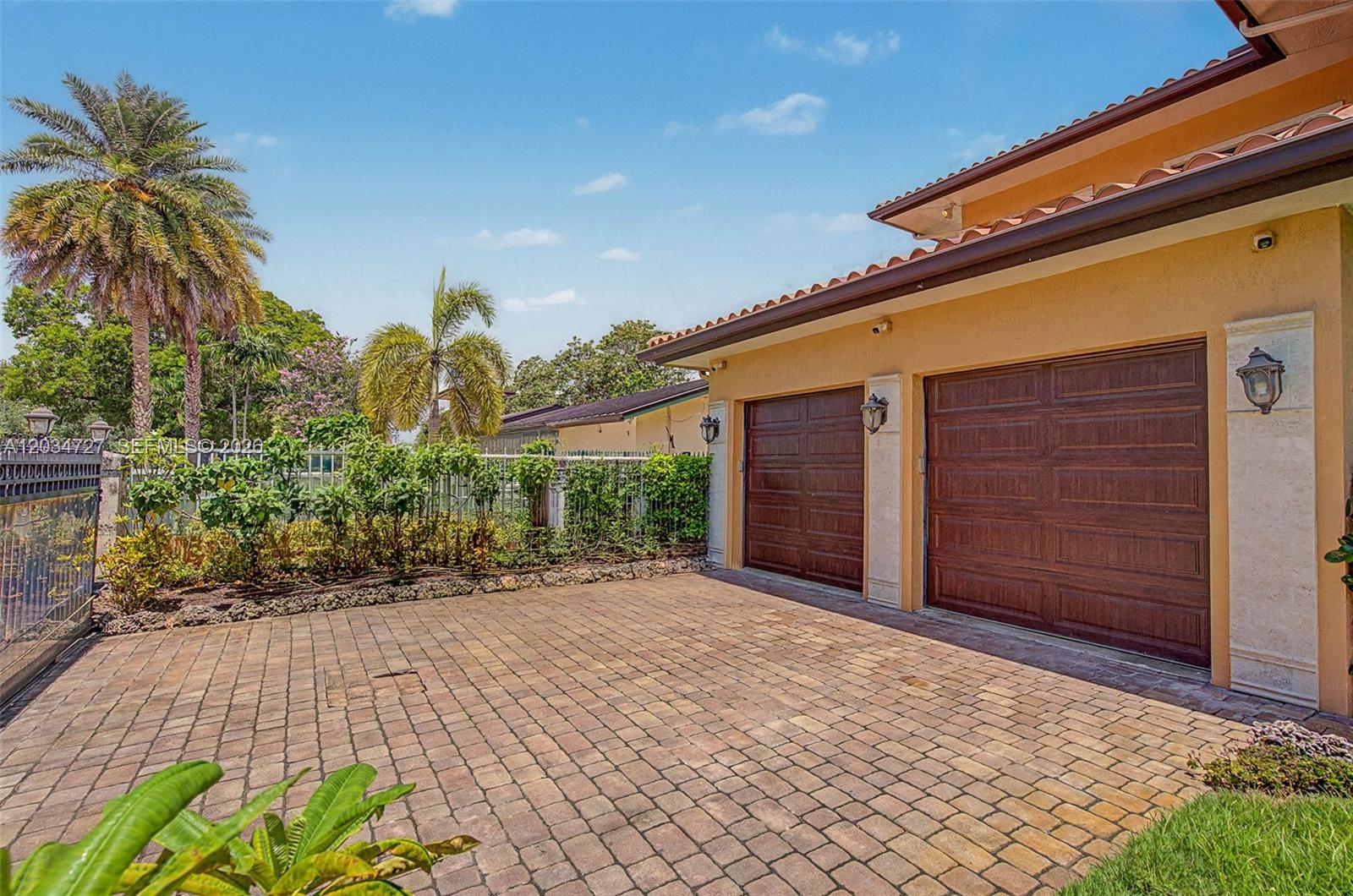 A paved driveway leads to a two-car garage attached to a stucco house with palm trees — 4251 SW 11th St, Miami FL 33134, MIAMI, FL