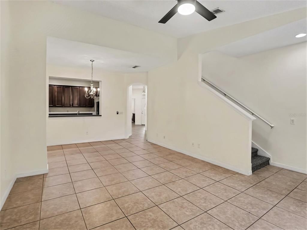 An interior view shows a tiled living area with a staircase and a kitchen pass-through — 1114 LIMESTONE RUN, SANFORD, FL