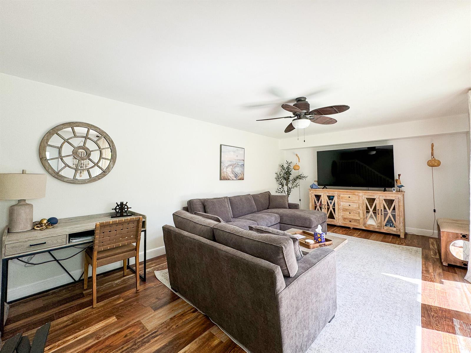A living room features a grey sectional sofa, a wooden desk, and a television console — 2821 28th Court, Jupiter FL 33477, JUPITER, FL