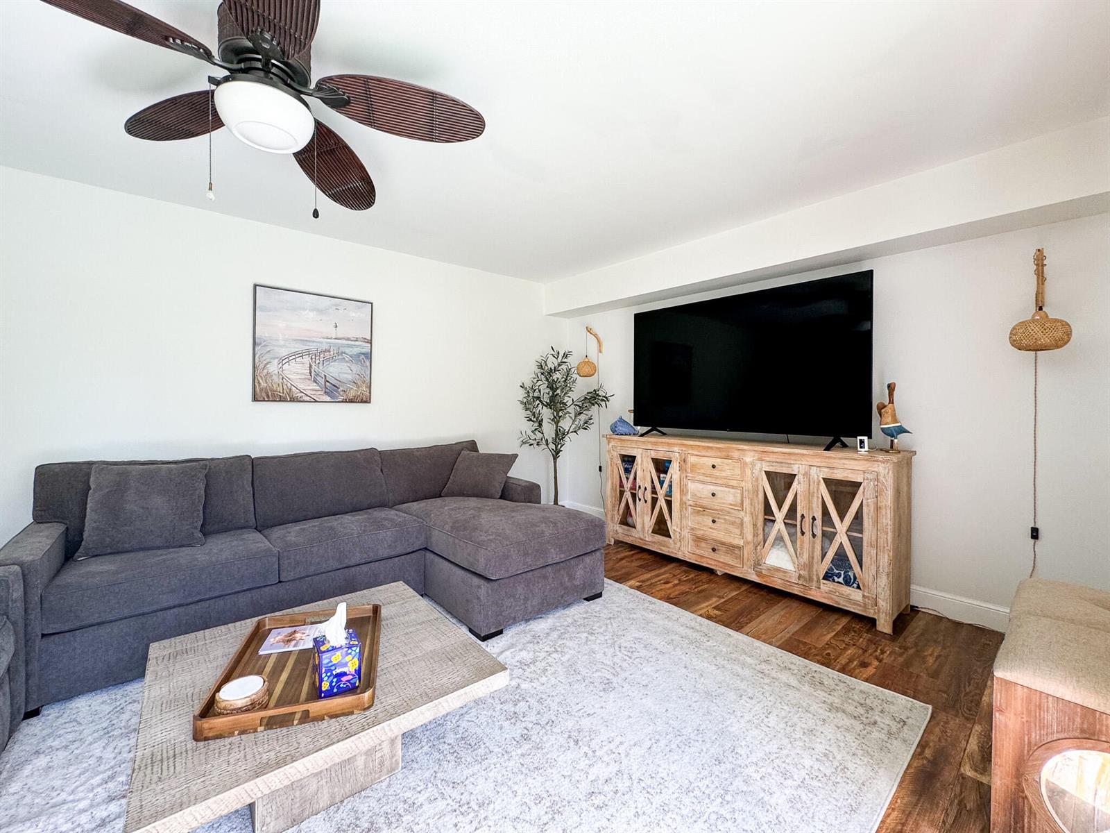 A living room features a gray sectional sofa, a wooden media console, and a ceiling fan — 2821 28th Court, Jupiter FL 33477, JUPITER, FL