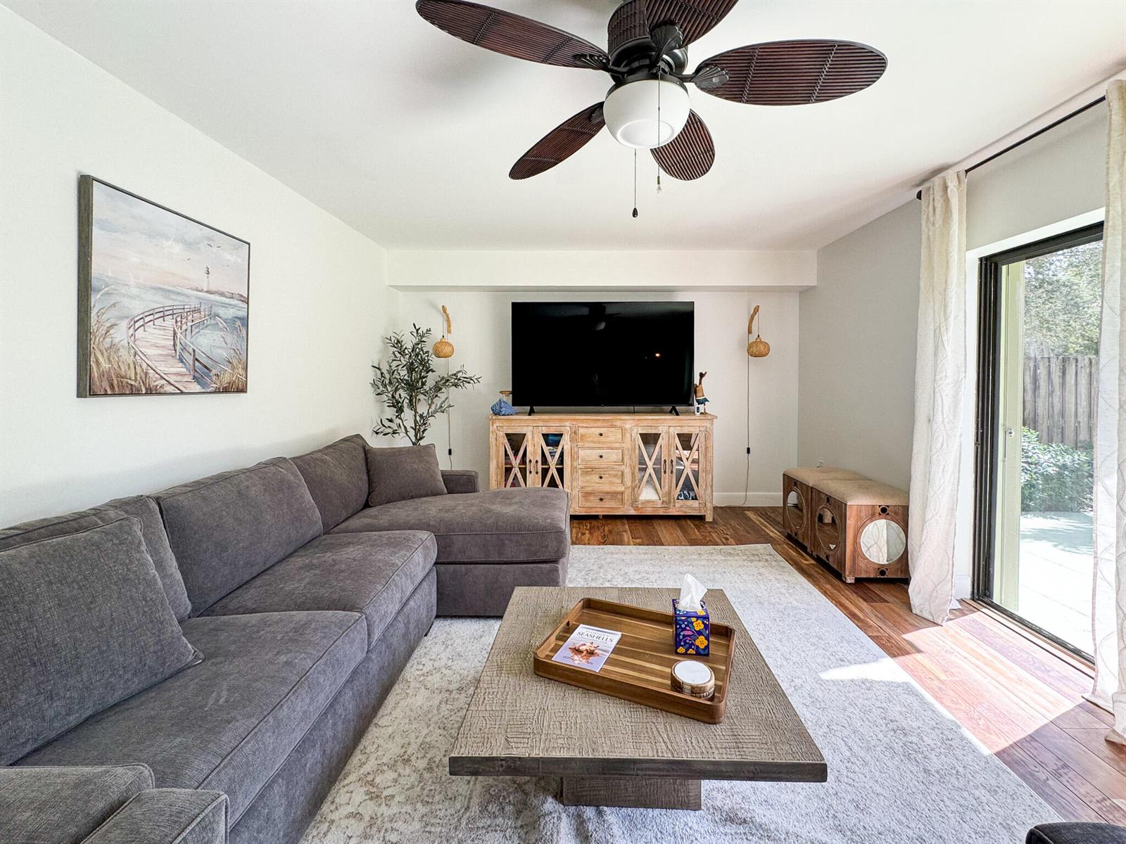 A living room features a grey sectional sofa, a wooden media console, and a ceiling fan — 2821 28th Court, Jupiter FL 33477, JUPITER, FL