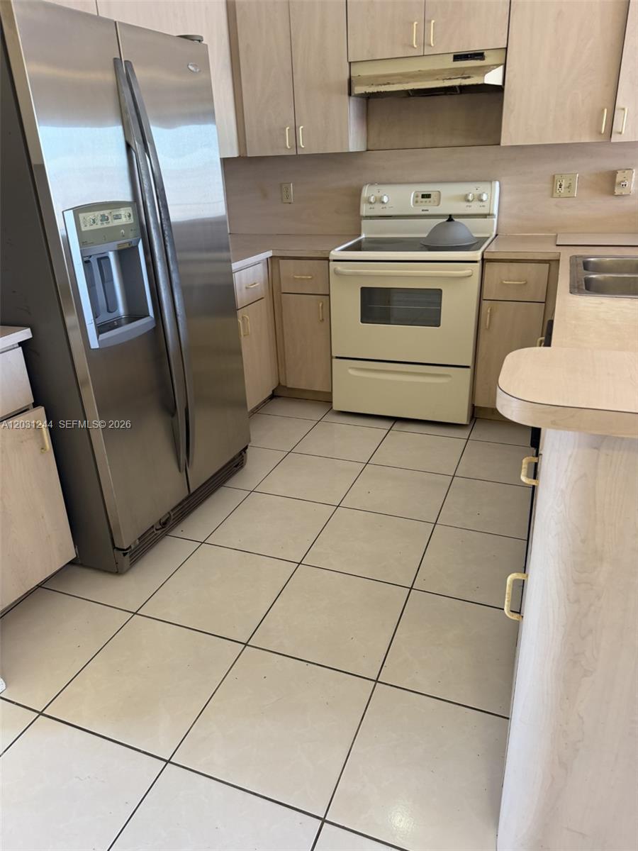 A kitchen features light wood cabinets, a stainless steel refrigerator, and a white electric stove — 13752 SW 156th St, Miami FL 33177, MIAMI, FL