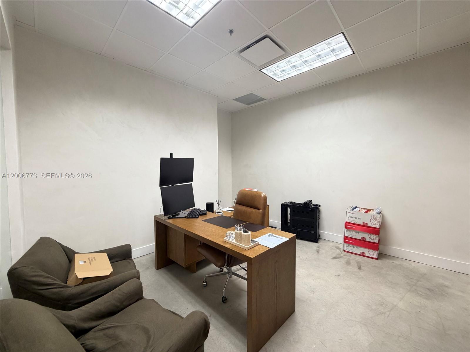 An office features a wooden desk, dual monitors, two armchairs, and stacked paper boxes — 3015 Grand Ave # 0210, Miami FL 33133, MIAMI, FL