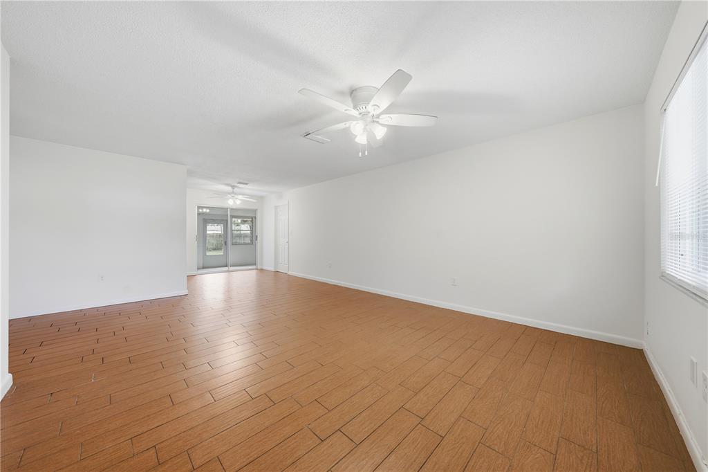 This is a digital rendering of a living room with a sofa, television, and rug — 205 PONCE STREET, NEW SMYRNA BEACH, FL