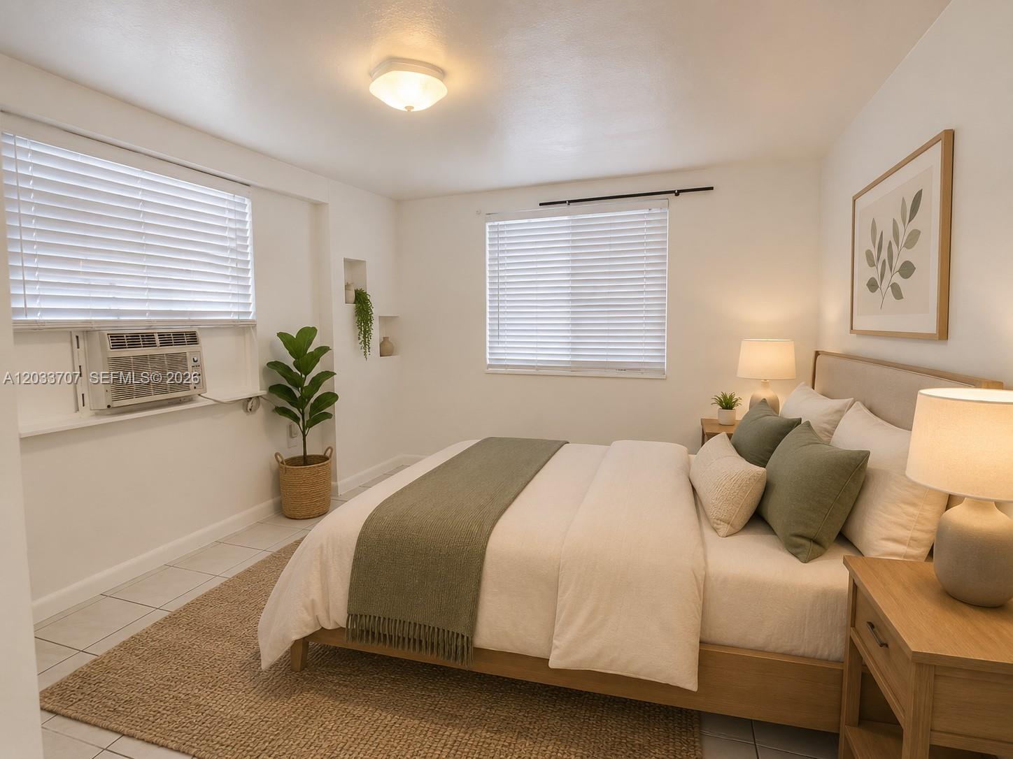A bedroom features a bed with green accents, a window air conditioner, and white walls — 2500 Sunshine Blvd, Miramar FL 33023, MIRAMAR, FL