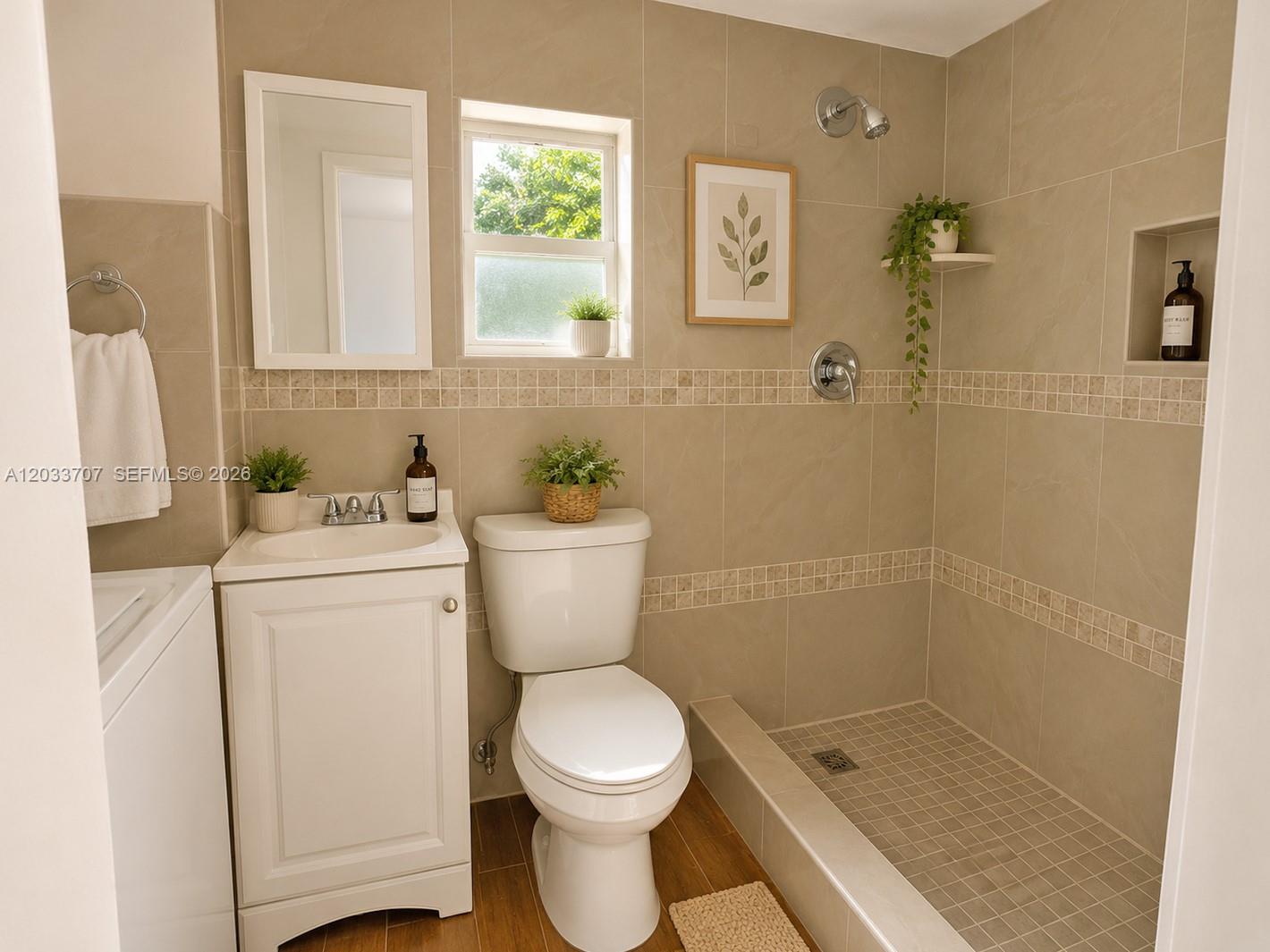 A bathroom features a walk-in shower, a white vanity, a toilet, and beige tile walls — 2500 Sunshine Blvd, Miramar FL 33023, MIRAMAR, FL