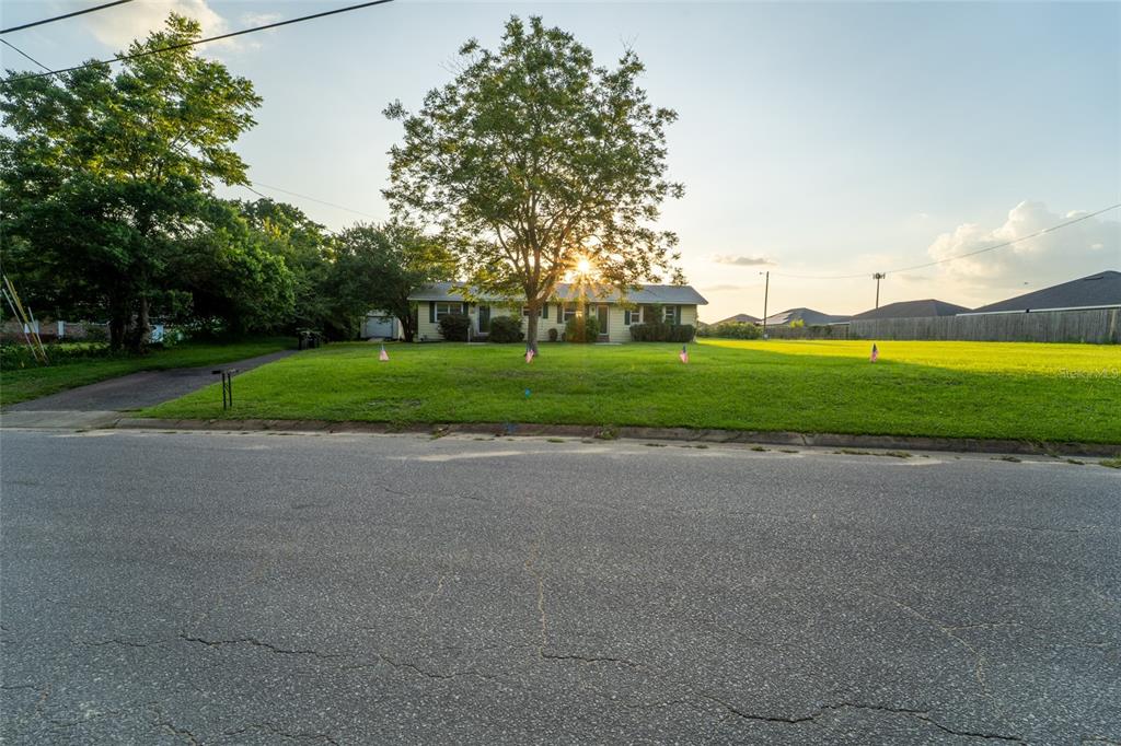 A single-story house with a large front yard and a tree sits behind a street — 6915 KLONDIKE ROAD, PENSACOLA, FL