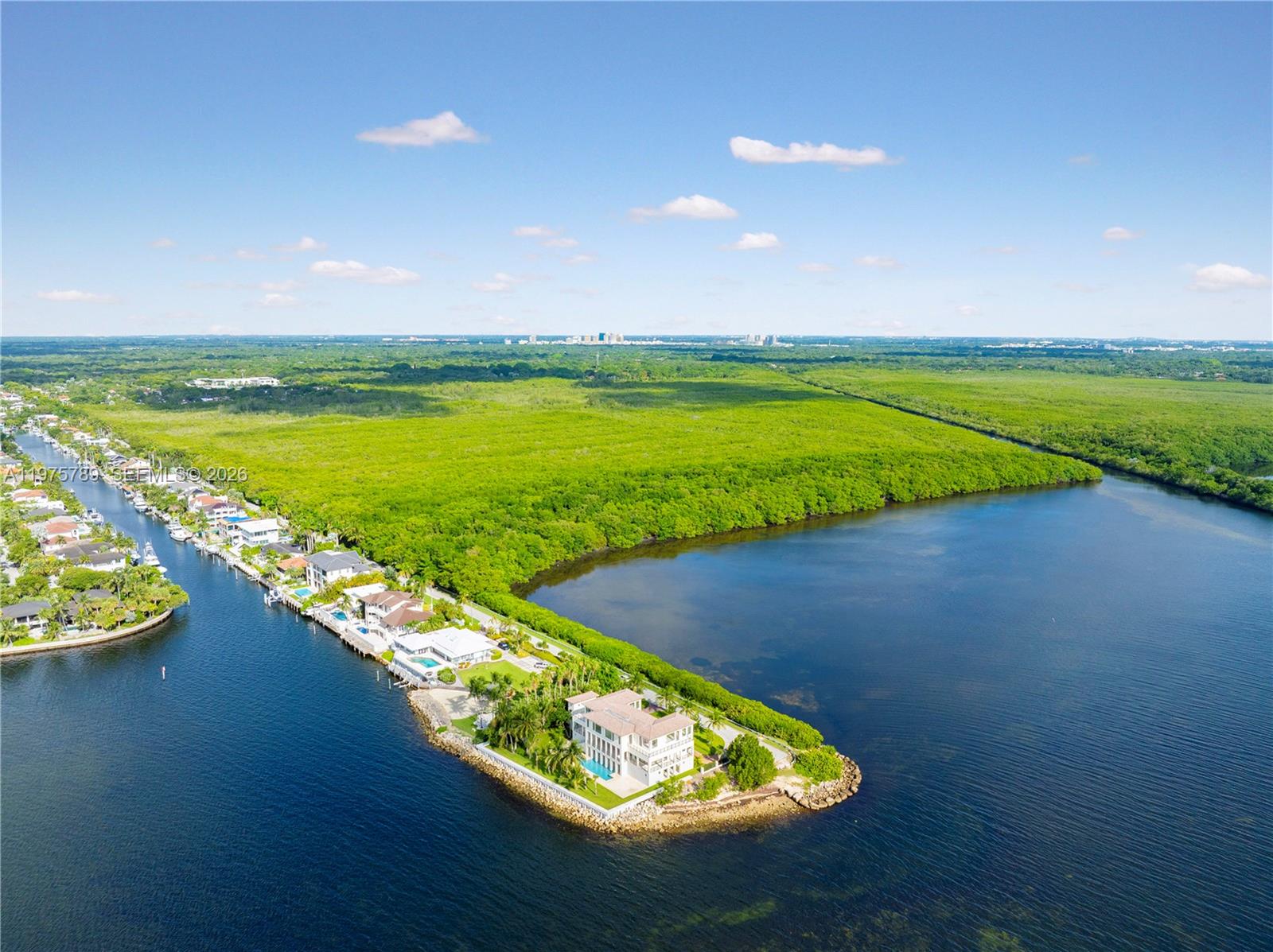 An aerial view shows a luxury waterfront home situated on a point of land — 650 Lugo Ave, Coral Gables FL 33156, CORAL GABLES, FL