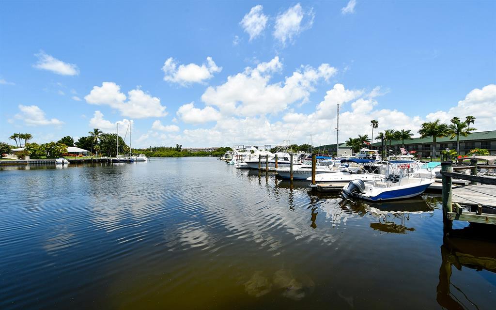 A marina with several docked boats under a blue sky with scattered clouds — 7150 N TAMIAMI TRAIL UNIT S-614, SARASOTA, FL