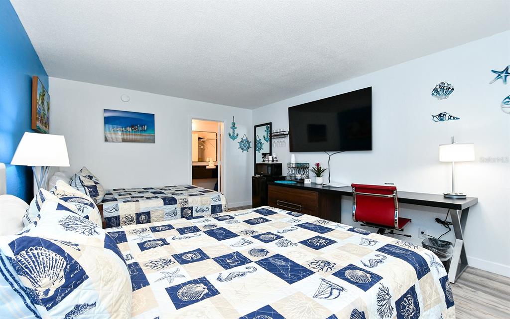 A bedroom with two beds, a desk, and coastal-themed decor — 7150 N TAMIAMI TRAIL UNIT S-614, SARASOTA, FL