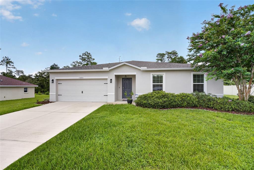A single-story house with a light-colored exterior, a two-car garage, and a front lawn — 15685 SW 40TH AVENUE, OCALA, FL