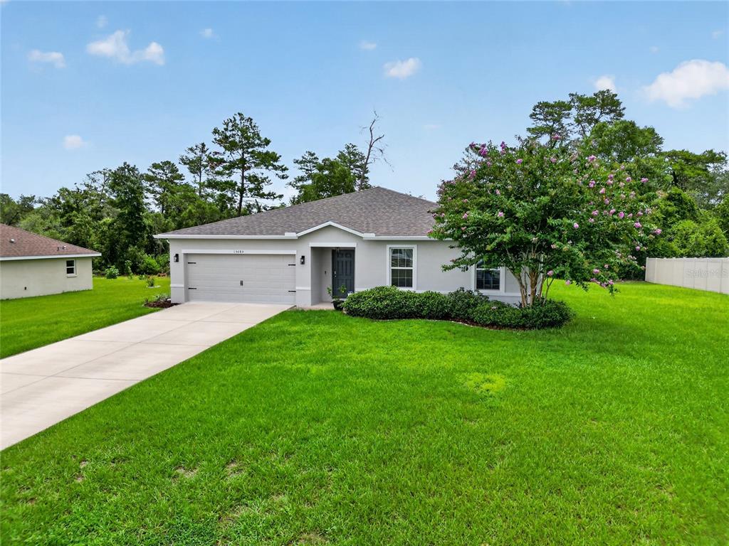 A single-story house with a two-car garage, gray exterior, and a large front lawn — 15685 SW 40TH AVENUE, OCALA, FL