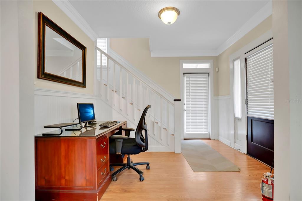 A home office area features a wooden desk, a black chair, and a staircase — 901 E WASHINGTON STREET, ORLANDO, FL