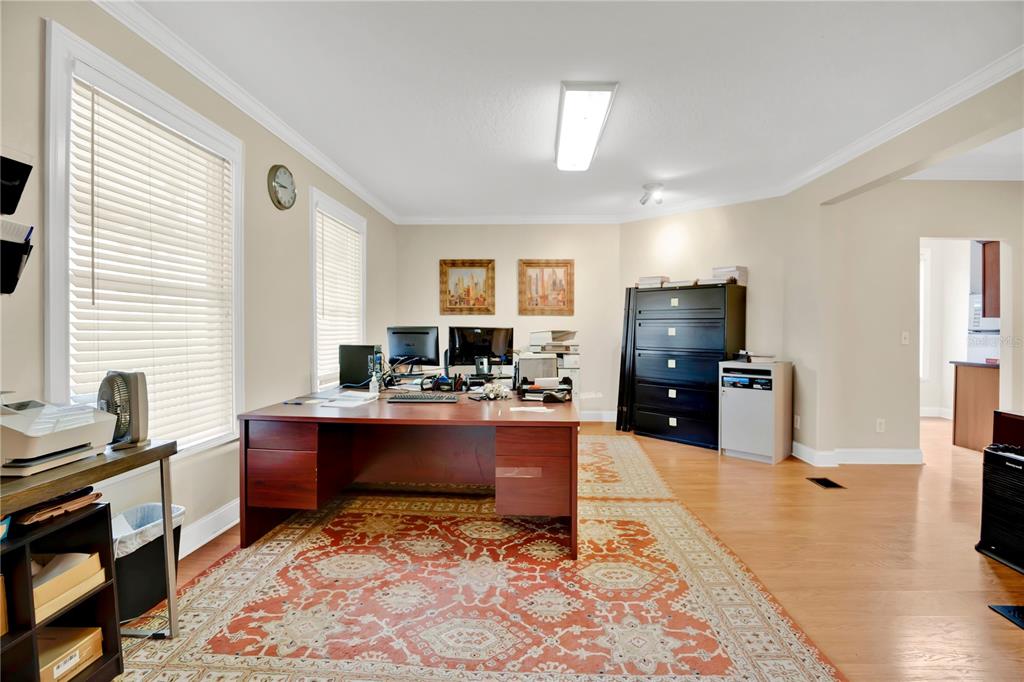 A home office features a large wooden desk, a patterned rug, and a tall filing cabinet — 901 E WASHINGTON STREET, ORLANDO, FL
