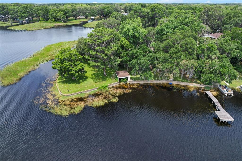 An aerial view of a grassy waterfront property with a small shed and wooden dock — 1226 S TELEPHONE POINT ROAD, INVERNESS, FL