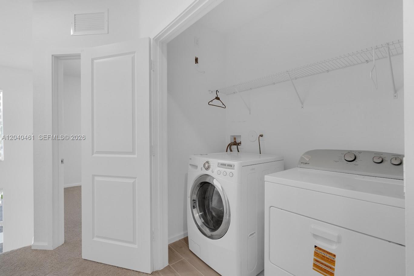 A laundry closet contains a white front-load washer and a top-load dryer — 805 SE 18th St, Homestead FL 33034, HOMESTEAD, FL