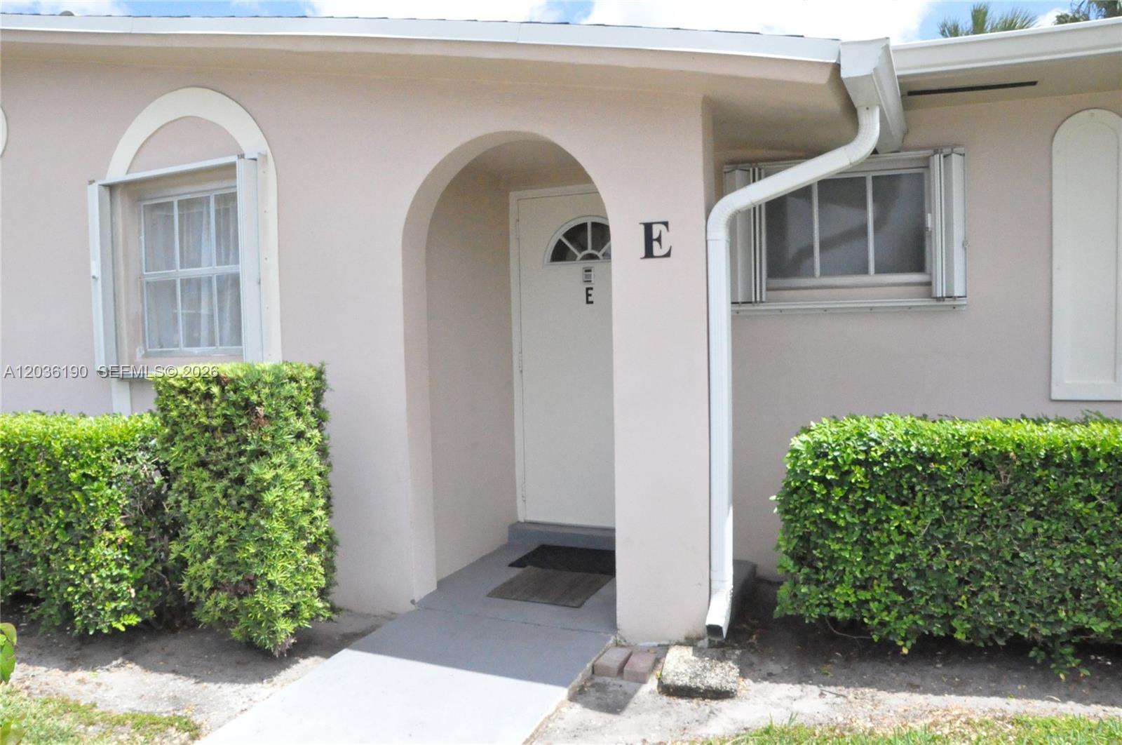 The exterior of a residential unit features a white arched doorway marked with the letter E — 2784 E Dudley Dr E, West Palm Beach FL 33415, WEST PALM BEACH, FL