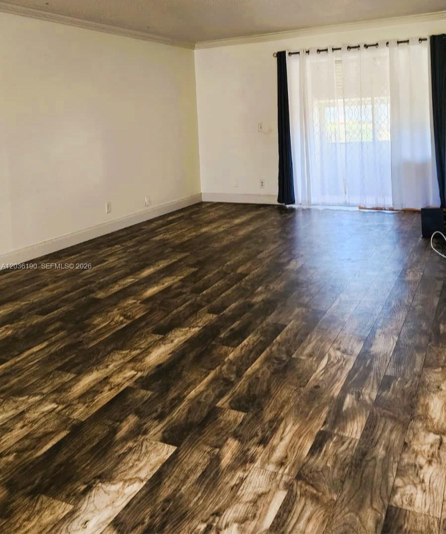 A room with wood-look flooring, white walls, and a sliding glass door with curtains — 2784 E Dudley Dr E, West Palm Beach FL 33415, WEST PALM BEACH, FL