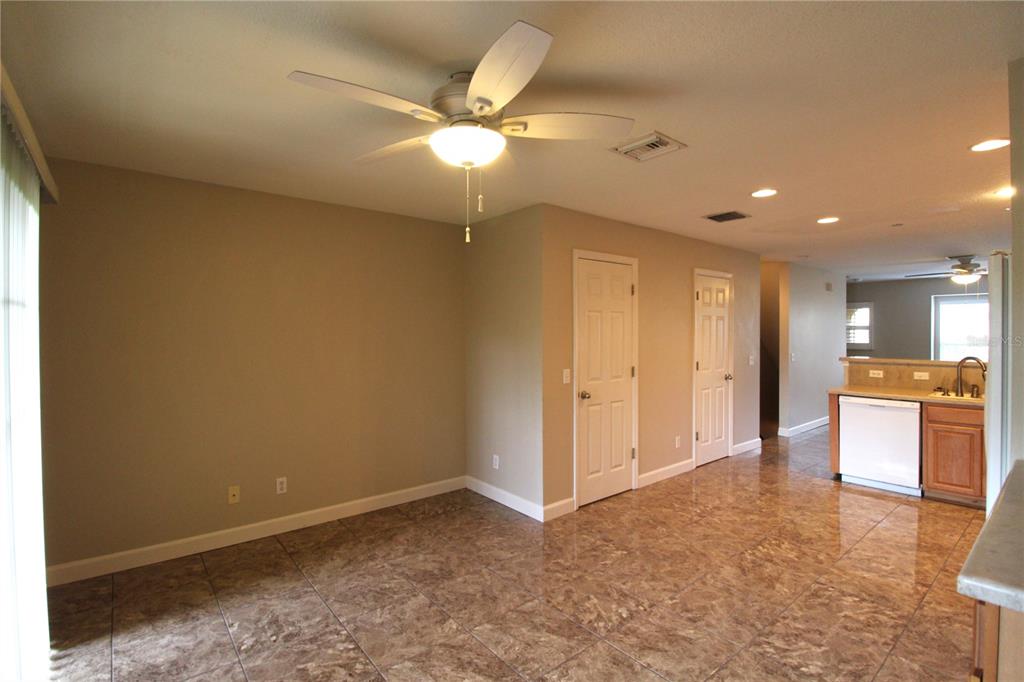 A dining area with tile flooring, a ceiling fan, and an adjacent open kitchen — 8828 WHITE SAGE LOOP, BRADENTON, FL