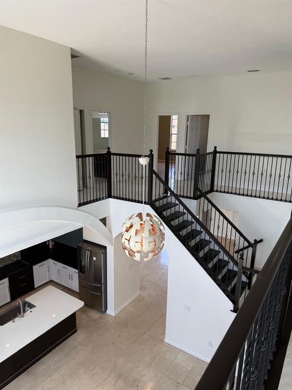 A high-angle view shows a kitchen with white cabinets and a staircase with black railings — 13406 MEADOW BAY LOOP, ORLANDO, FL