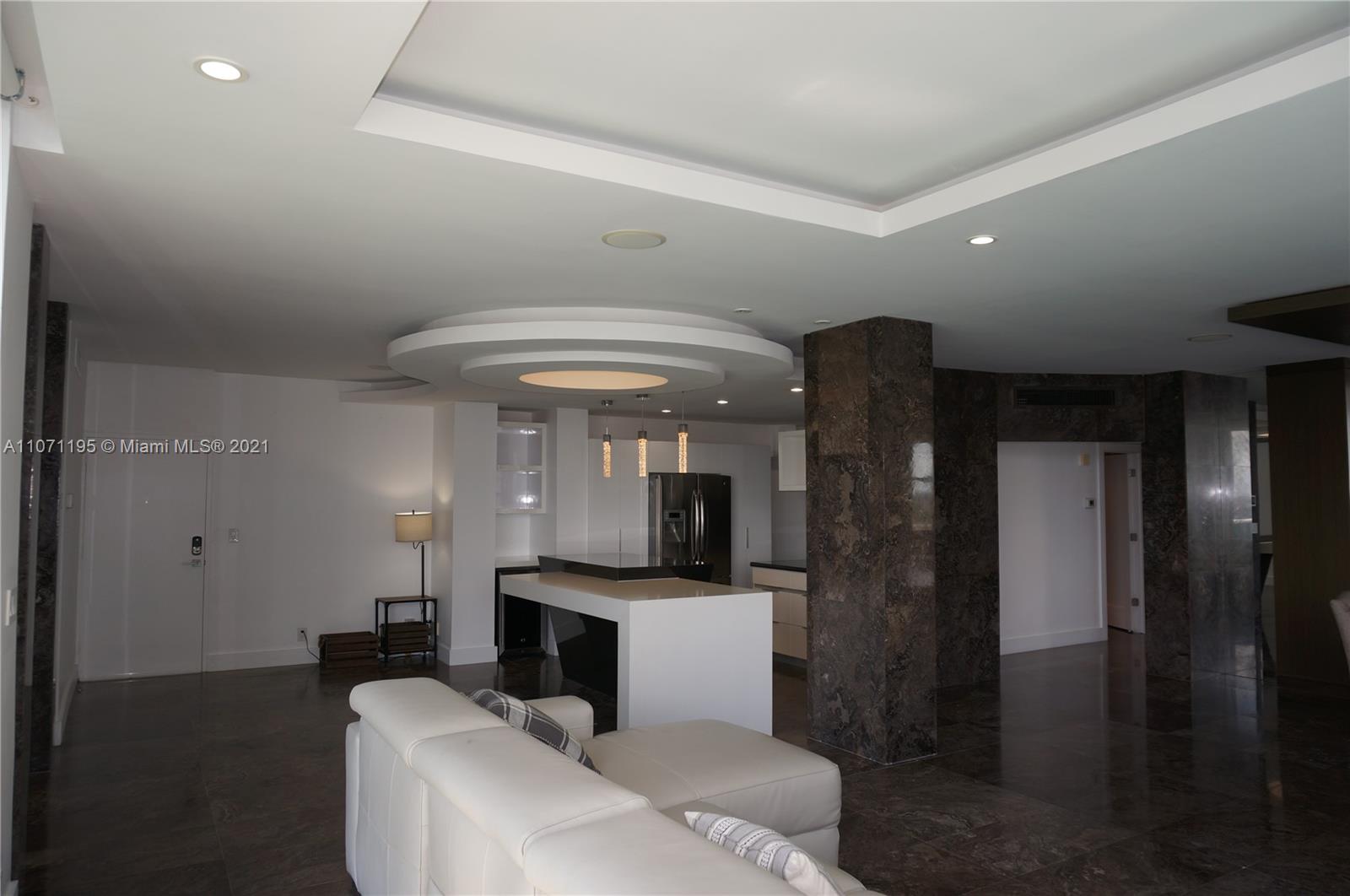 A modern living room features a white sectional sofa, marble flooring, and a circular ceiling detail — 4001 S Ocean Dr, Hollywood FL 33019, HOLLYWOOD, FL