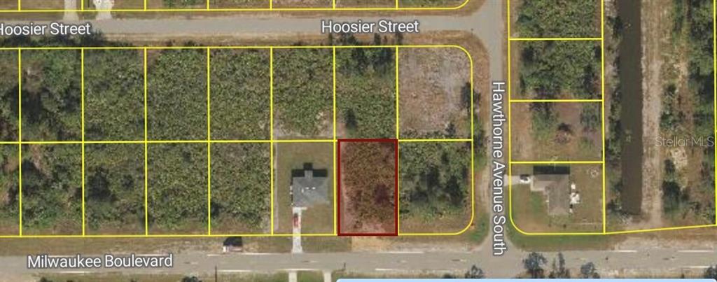 This is an aerial map showing a vacant rectangular lot highlighted in red — 881 MILWAUKEE BOULEVARD, LEHIGH ACRES, FL