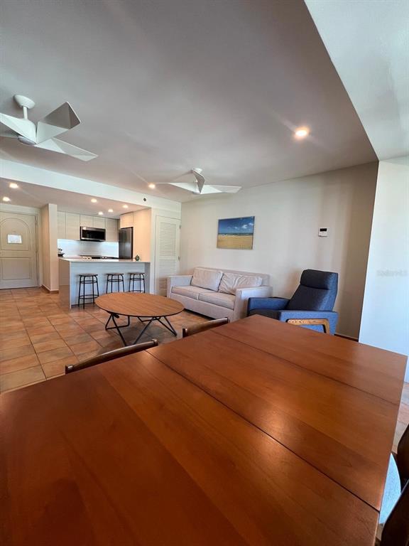 An open-concept living and dining area features a wooden table, sofa, and kitchen island — OCEAN VILLAS I 6000 BLVD. RIO MAR UNIT /, RIO GRANDE, PR