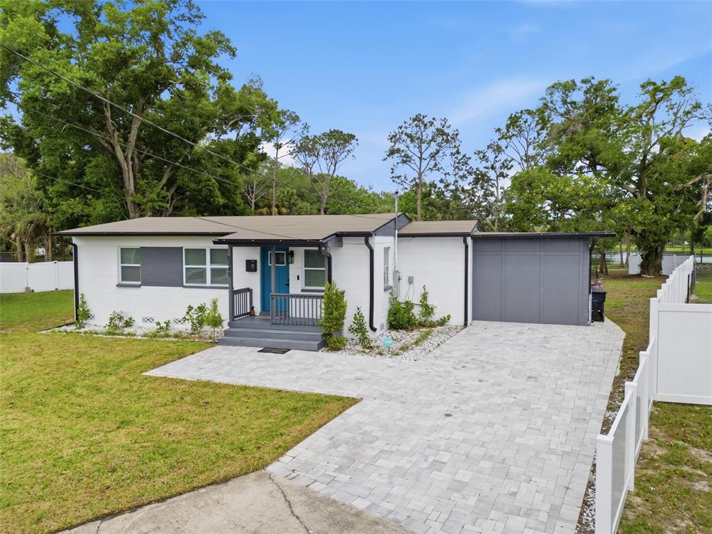 A single-story house with a white exterior, gray accents, and a paved driveway — 5345 AVON COURT, ORLANDO, FL