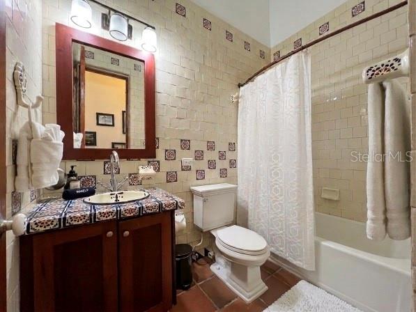 A bathroom features a wooden vanity with a tiled countertop, a toilet, and a shower-tub — 6000 BLVD RIO MAR UNIT 7105, RIO GRANDE, PR