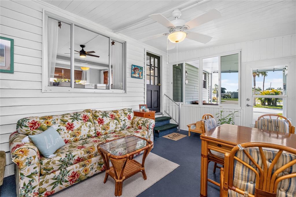 A sunroom features a floral sofa, a rattan coffee table, and a dining set — 6741 LAUREL COURT, NORTH PORT, FL