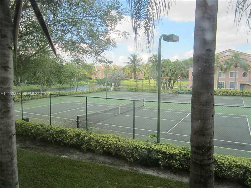 A living area features vaulted ceilings, tile flooring, a ceiling fan, and a sliding glass door — 12172 St Andrews Place # 211, Miramar FL 33025, MIRAMAR, FL