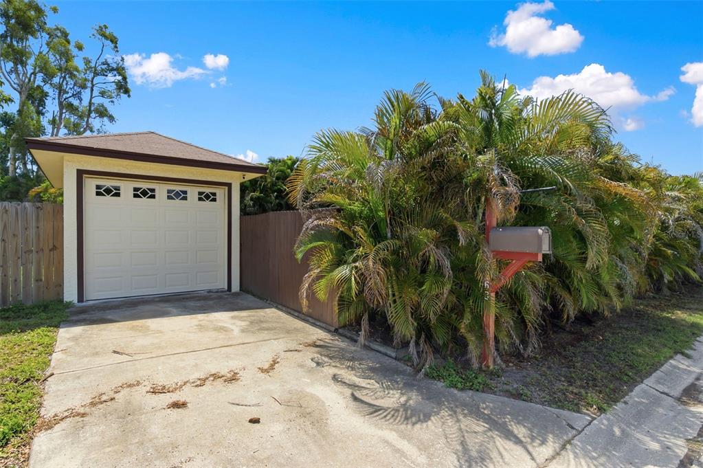 A detached garage with a white door sits next to a mailbox and palm trees — 4263 5TH AVENUE N, ST PETERSBURG, FL