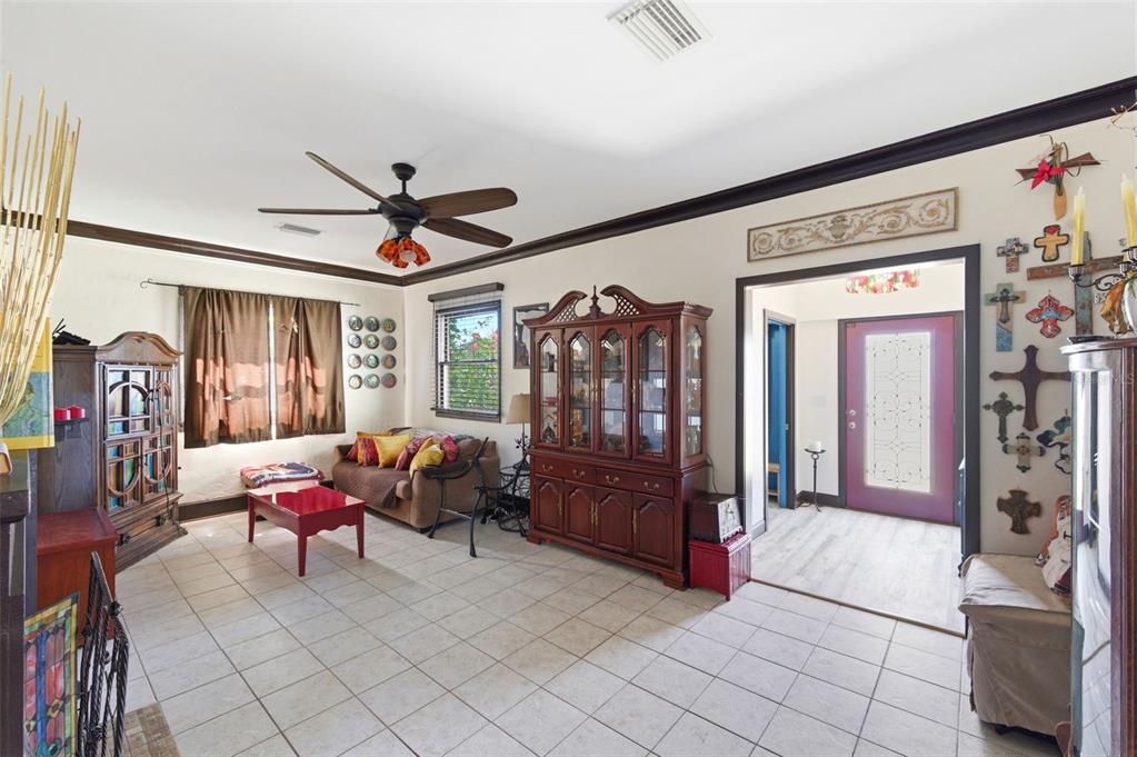 A living room with tile floors, a ceiling fan, wooden furniture, and a doorway entrance — 4263 5TH AVENUE N, ST PETERSBURG, FL