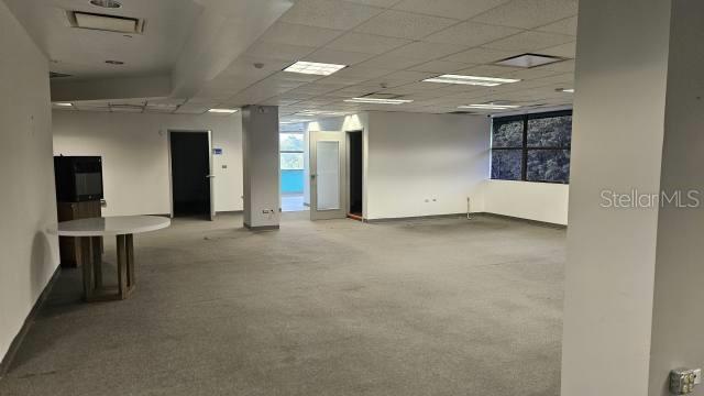 An empty office space features gray carpeting, a drop ceiling, and a round white table — 300 AVENIDA LAS CUMBRES, SAN JUAN, PR