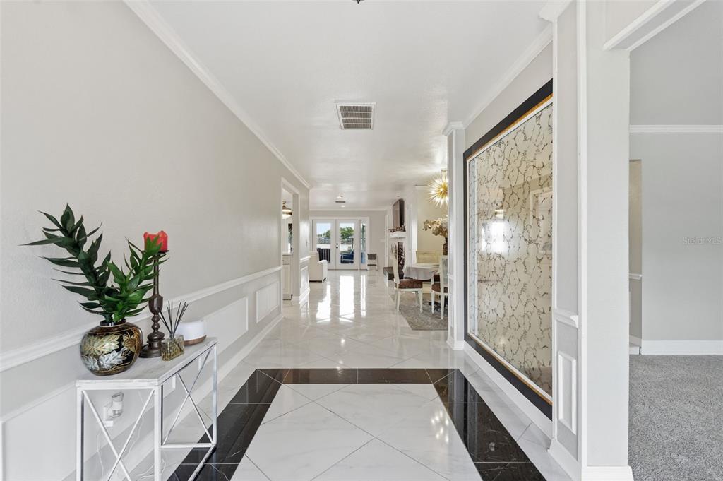 A bright hallway features white walls, wainscoting, and a floor with black and white tiles — 3678 E LAKE DRIVE, LAND O LAKES, FL