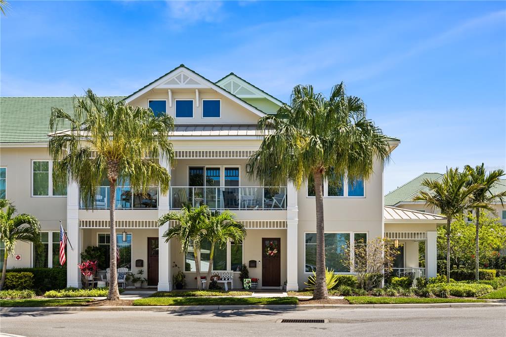 A two-story residential building with a balcony, palm trees, and a green shingled roof — 1 PALM TERRACE, BELLEAIR, FL