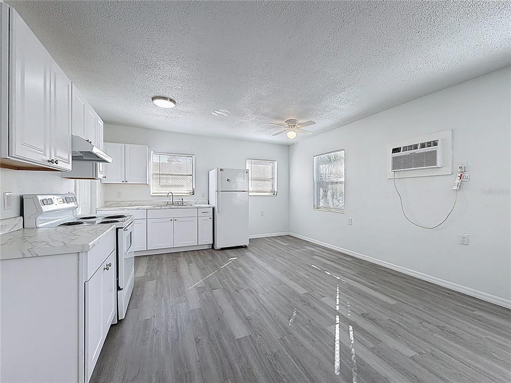 A kitchen with white cabinets, stainless steel appliances, and gray wood-look flooring — 650 E HARBOR DRIVE S, ST PETERSBURG, FL