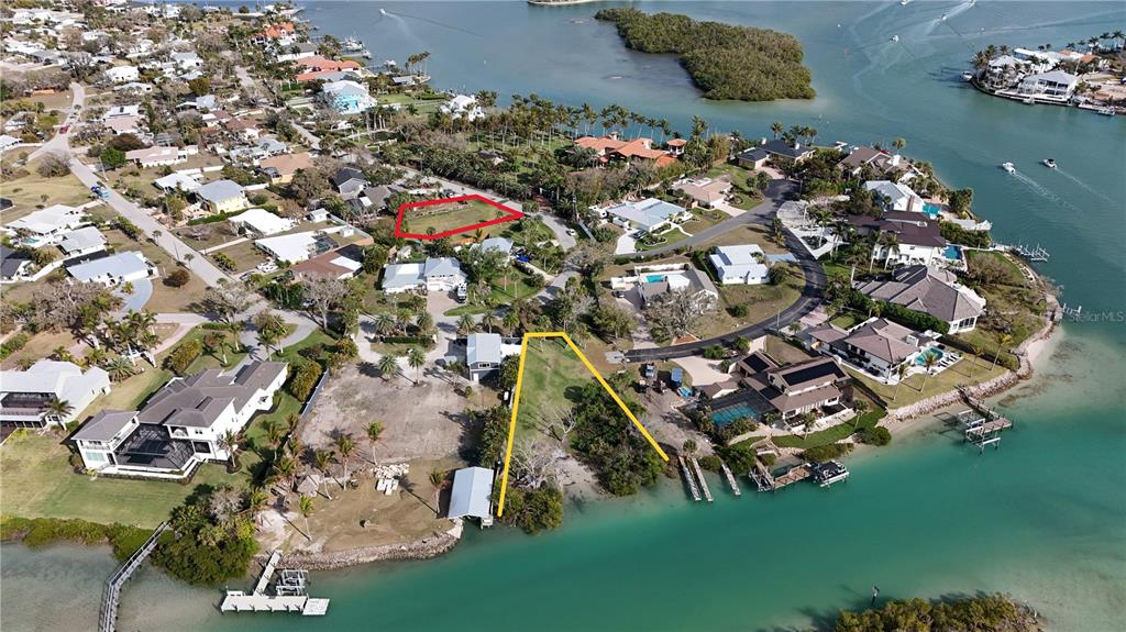 An aerial view shows two waterfront residential lots outlined in red and yellow — 514 BAYVIEW PARKWAY, NOKOMIS, FL