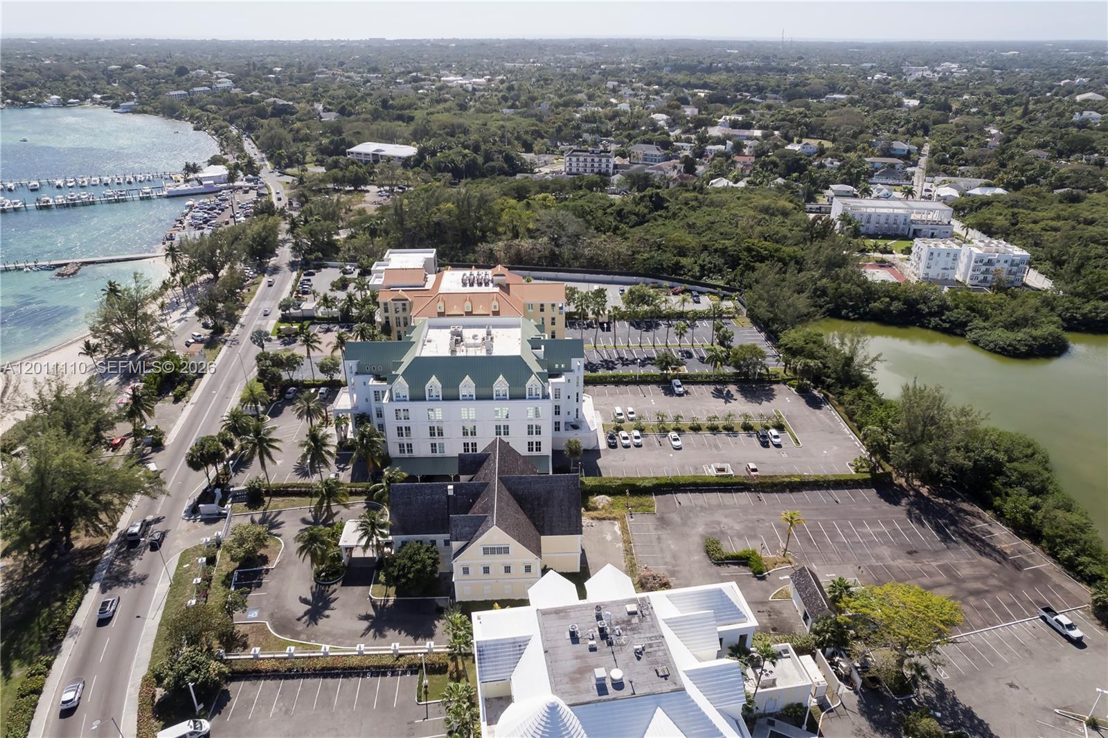 An aerial view shows a large hotel complex with multiple buildings, parking lots, and surrounding greenery — 9 E Bay Street, 00000, FL
