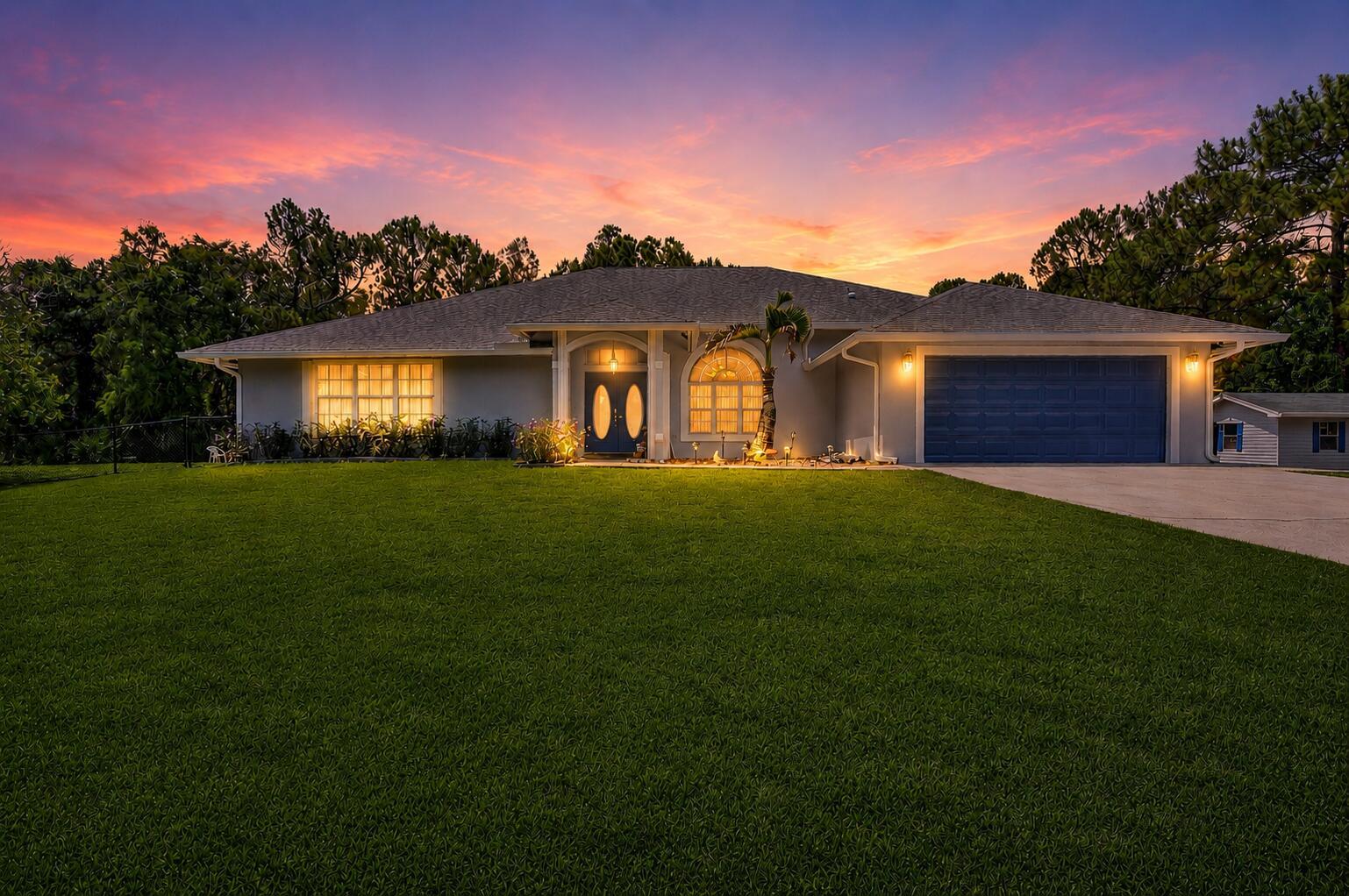 A single-story house with a blue garage door and front door at sunset — 16074 66th Court N, FL 33470, FL