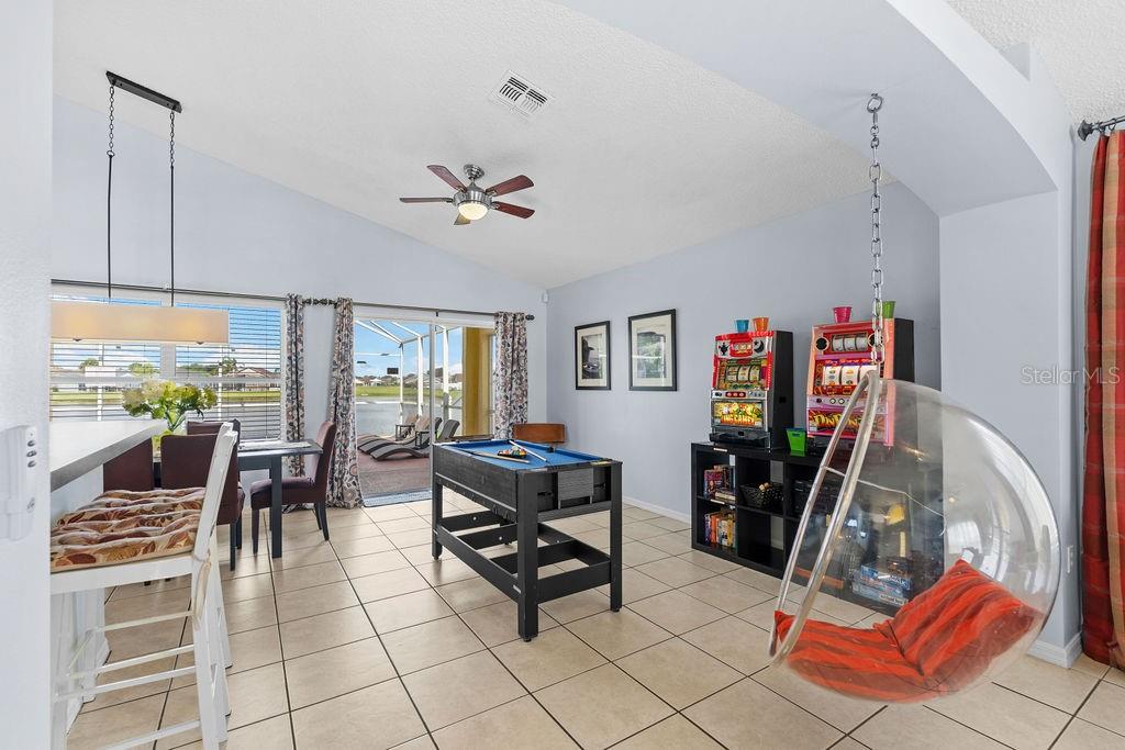 A game room features a pool table, two slot machines, and a hanging bubble chair — 5134 VIOLET LANE, KISSIMMEE, FL