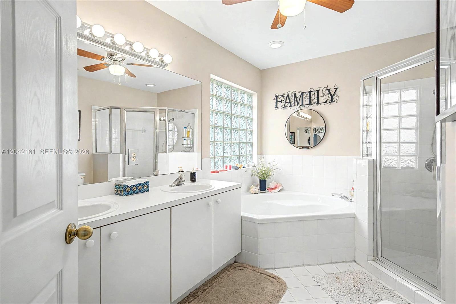 A bathroom features a white double vanity, a corner soaking tub, and a glass shower — 14033 SW 155th Ct, Miami FL 33196, MIAMI, FL