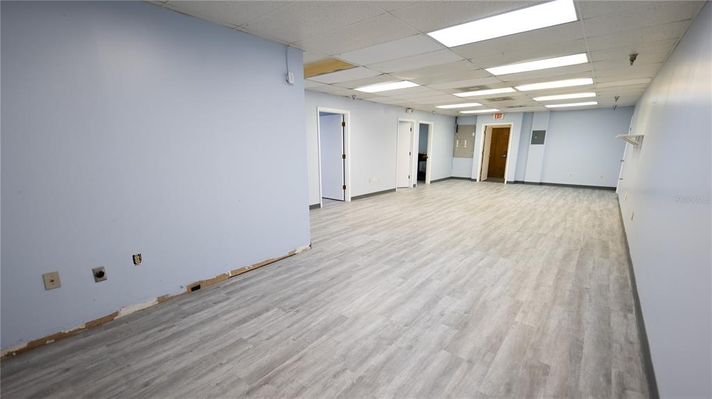 An empty commercial office space with light blue walls, wood-look flooring, and a drop ceiling — 1209 TECH BOULEVARD UNIT 207, TAMPA, FL