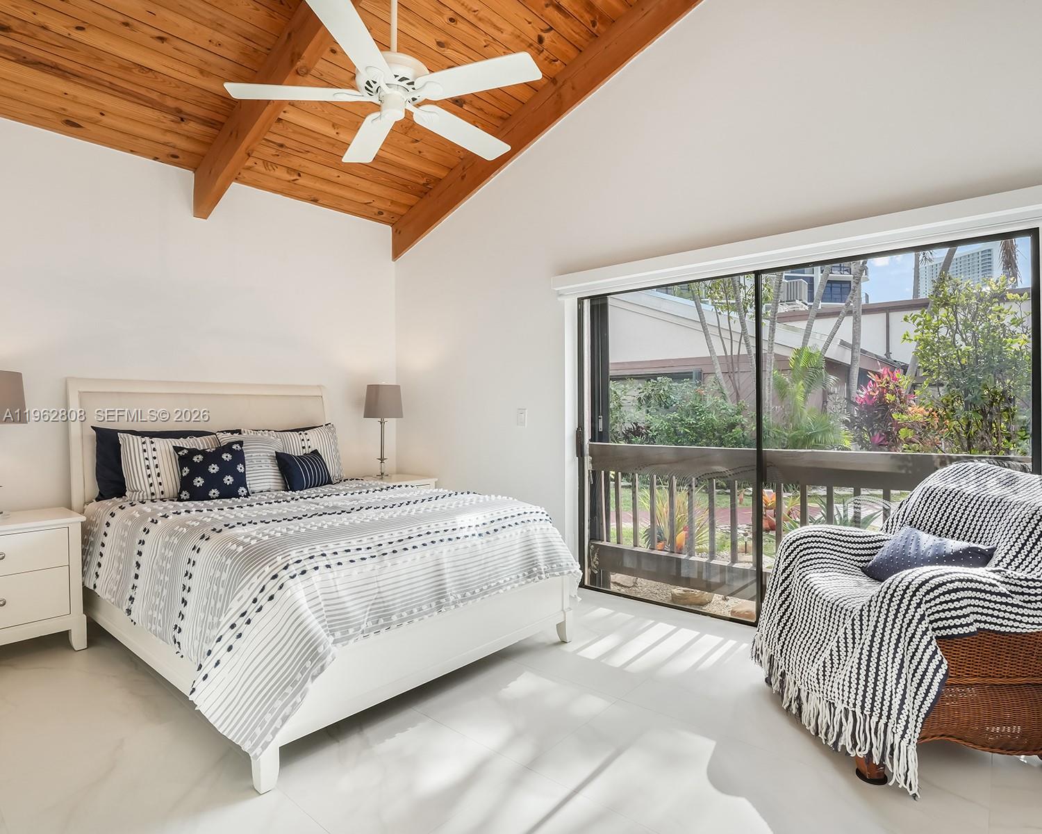 A bedroom features a vaulted wood-paneled ceiling, a white bed, and a sliding glass door — 413 Leslie Dr, Hallandale Beach FL 33009, HALLANDALE BEACH, FL