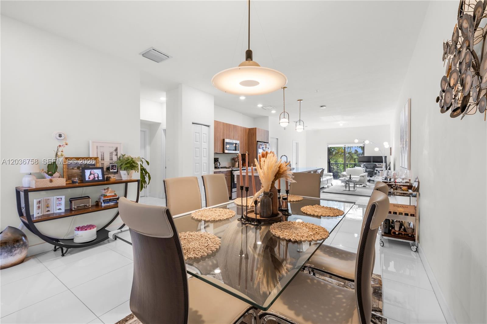 A dining area with a glass table and chairs leads into an open-concept kitchen — 7925 NW 104th Ave # 21, Doral FL 33178, DORAL, FL
