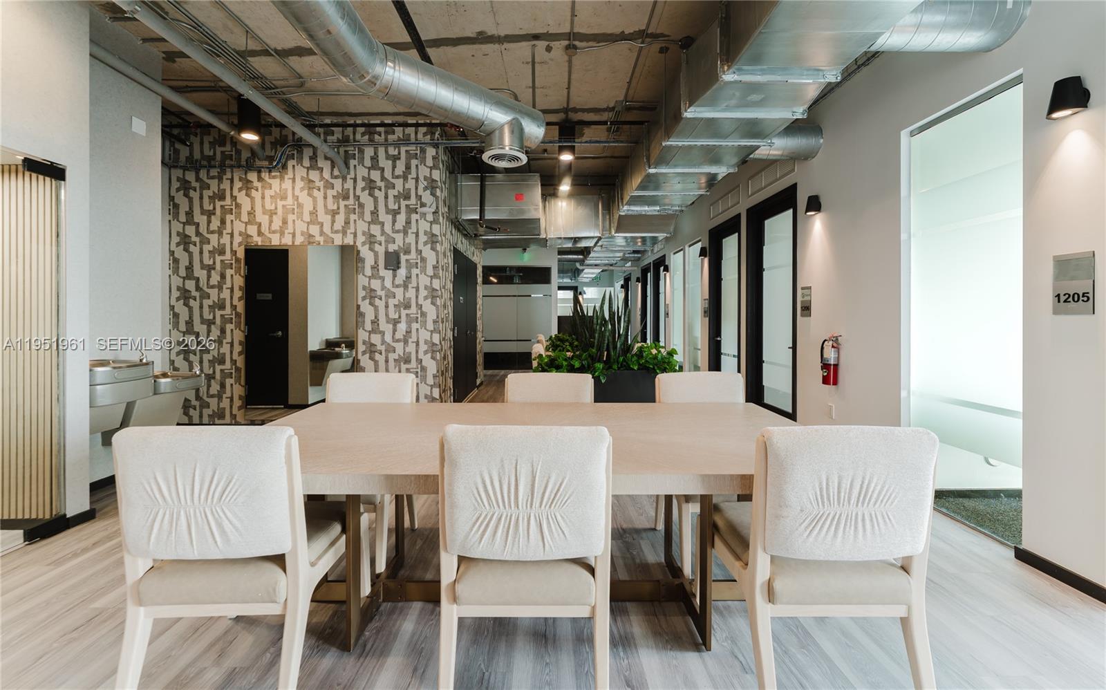 A modern office conference room features a large table, upholstered chairs, and exposed industrial ductwork — 420 SW 7th St # 1017, Miami FL 33130, MIAMI, FL